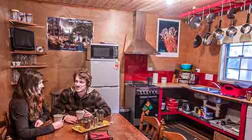 Young couple sitting at the kitchen table in the Settlers Hut